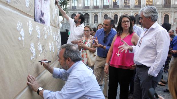  Jesús Labrador firma en el mural instalado en la plaza del Ayuntamiento./ Ana Pérez.